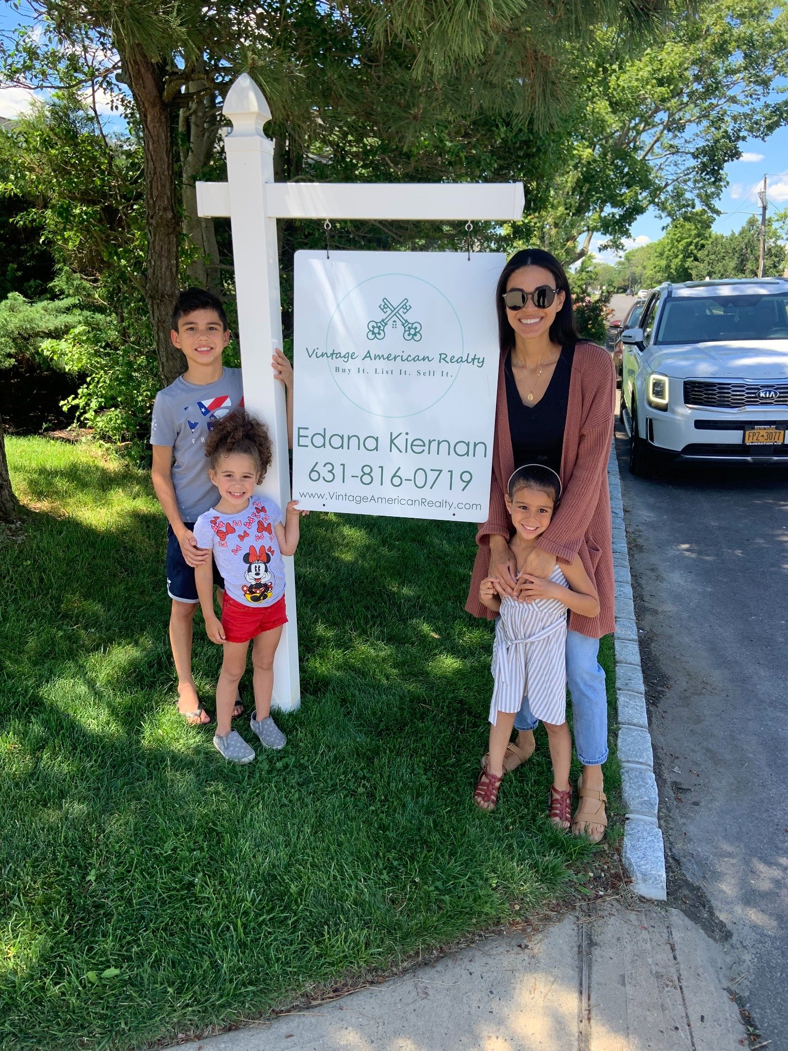 Edana Kiernan and family beside a Vintage American Realty sign
